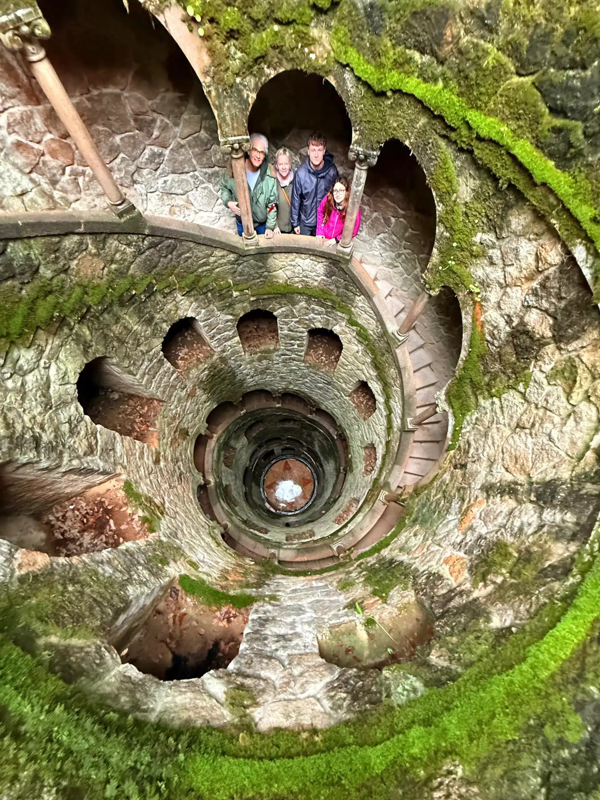 Visitors inside the Initiation Well at Quinta da Regaleira in Sintra