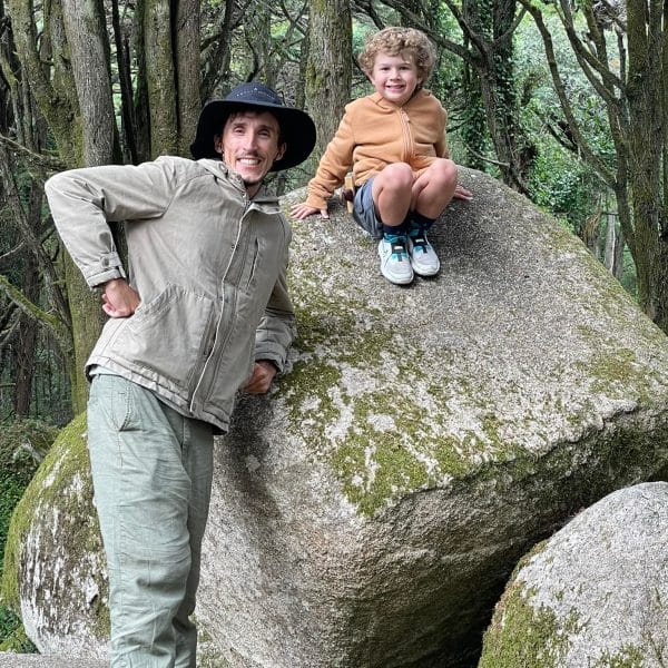 Daniel Ponce with a young boy on a large mossy boulder in the Sintra forest, Portugal – enjoying a nature break during a private family-friendly tour with Yes, You Deserve!