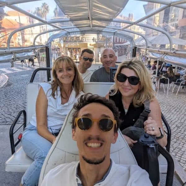 Group of tourists enjoying a sunny private tuk tuk tour in the historic center of Sintra with Daniel Ponce from Yes, You Deserve! – exploring charming cobblestone streets and colorful architecture in comfort.